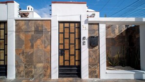 A modern building with a distinctive entrance featuring a geometric door design and a small staircase leading up to it.