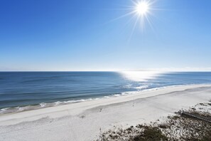 A beach with a clear sky and the sun shining. - White Caps 1202 by Liquid Life (Orange Beach)