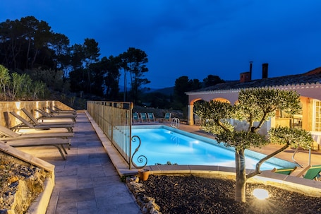 Una piscina al aire libre, sillones reclinables de piscina