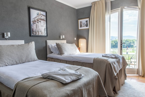 A hotel room with two beds, a large window with a view, and a framed picture on the wall. - Domaine Rabiega - Vignoble et Boutique Hotel (Draguignan)
