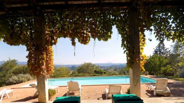 Ein Poolbereich mit Liegestühlen und Blick auf die Landschaft.