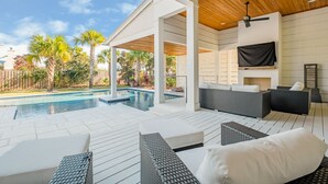 A covered outdoor area with a pool, lounge chairs, and a seating area with cushions. - Private Neighborhood beach access, large pool, golf cart, walk to beach/dine (Santa Rosa Beach)