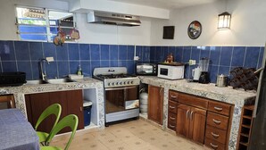 A kitchen with blue tiles, a stove, oven, microwave, and a refrigerator. - BEAUTIFUL APARTMENT IN FRONT OF THE SEA (Portobelo)