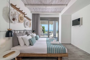 Ein modernes Hotelzimmer mit einem großen Bett, einem Fernseher und Blick ins Freie.