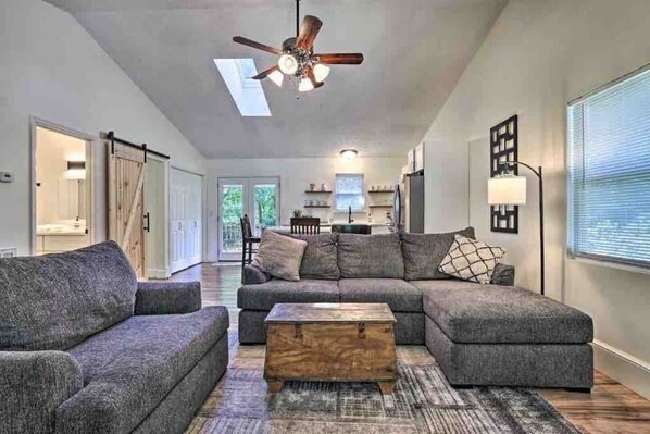 A modern living room with a sectional sofa, a coffee table, and a ceiling fan.