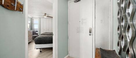 A bedroom with a bed, a dresser, and a door with a metal handle.