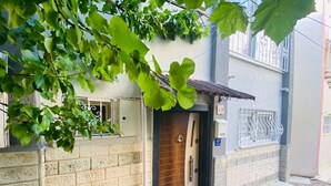 A house with a brick exterior, a wooden door, and a small porch. - Beautiful 3-bedroom House With Sea View and Garden (Kusadasi)