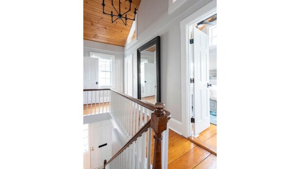 A staircase with wooden railings and a wooden ceiling.
