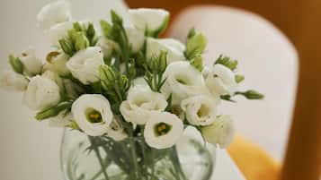 Un jarrón blanco con flores blancas sobre una mesa blanca.