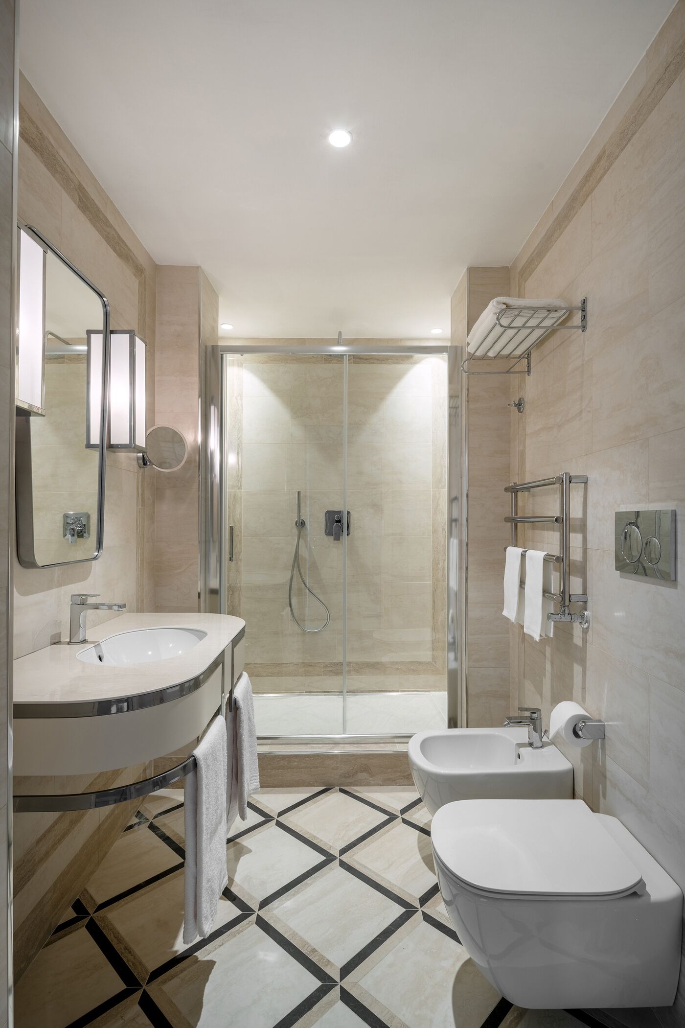 Un baño moderno con ducha de vidrio, un lavabo con espejo y un inodoro.