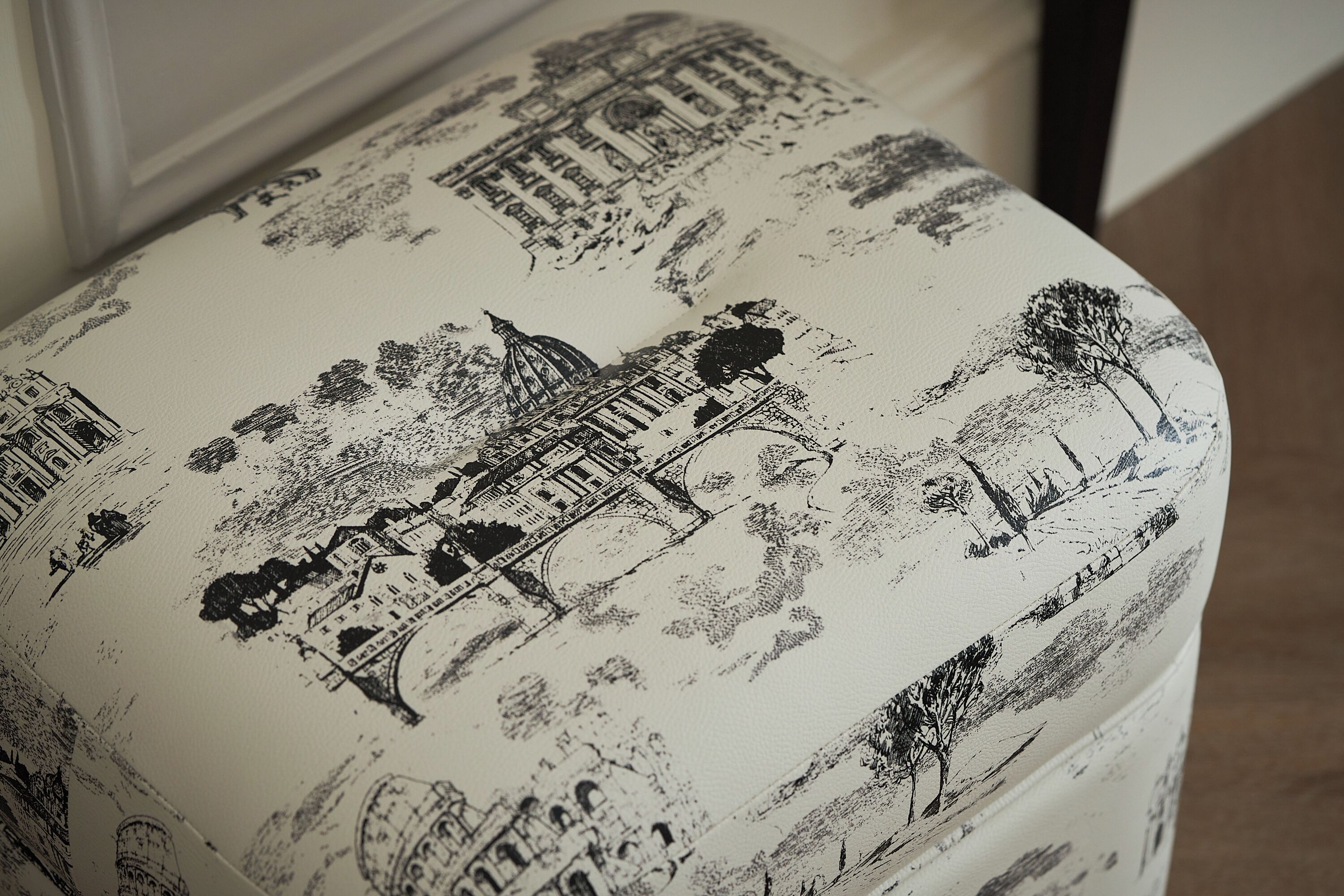 A close-up of a fabric with black and white illustrations of buildings and trees.