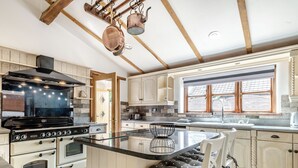 Une cuisine dotée d’un îlot central, de meubles en bois, d’une cuisinière et d’une fenêtre offrant une belle vue.