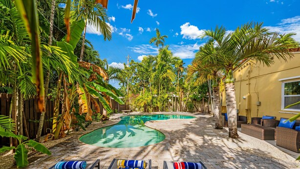 A pool area with lounge chairs and a pool.