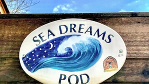 A decorative sign with the text "SEA DREAMS POD" and a wave illustration.