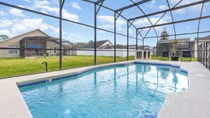 A swimming pool with a clear view of the surrounding area, including houses and a grassy lawn. - Close To Theme Parks - Private Pool! (Kissimmee)