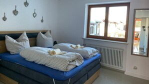 Une chambre à coucher avec un lit, une fenêtre, un radiateur et des décorations murales en forme de cœur.