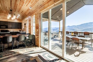 A wooden interior with a kitchen, dining area, and a balcony with a mountain view. - Sky Ridge Cabin: Hot Tub, Swim Spa & Fun with Panoramic Views (Gatlinburg)