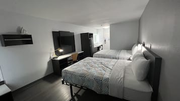 A hotel room with two beds, a desk with a chair, a TV, and a mirror.