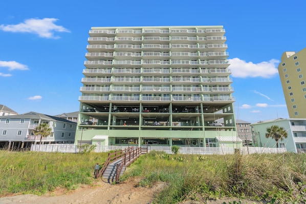 A multi-story parking garage with a pedestrian bridge leading to a building.