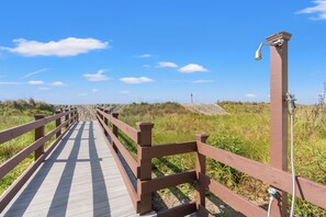 Une promenade en bois qui traverse un paysage naturel sous un ciel dégagé.