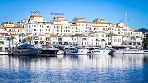 A marina with yachts docked, a hotel named 'BENABOLA' in the background, and a clear blue sky. - Pto. Banús, modern, bright, 2-bedroom Apart., pool (Puerto Banús)