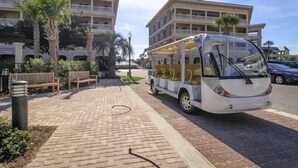 Um ônibus estacionado em área pavimentada, com um edifício ao fundo.