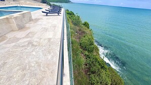 A pool area with lounge chairs overlooking a coastal view. - Oceanfront Casa Vista Fajardo (Fajardo)