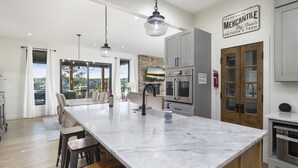 Un'ampia cucina con isola centrale, elettrodomestici moderni e vista sull'esterno.