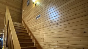 A wooden staircase with a handrail, leading to a landing with a light fixture and a small vent. - Cabin- no cleaning fees: Cranberry Fest, waterparks, trail riding for utv/atv (Warrens)