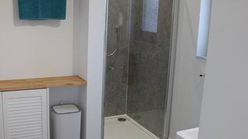 Un baño moderno con ducha, inodoro y lavabo.