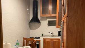 A compact kitchen with wooden cabinets, a built-in microwave, and a gas stove.