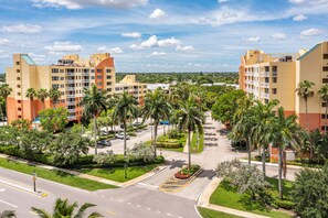 A multi-story hotel with balconies, surrounded by palm trees and a parking lot. - Vacation Village at Bonaventure (Weston)