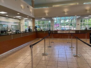 A reception area with a counter, glass partitions, and a tiled floor.
