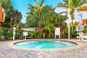 A swimming pool with a brick border, surrounded by palm trees and greenery. - Vacation Village at Bonaventure (Weston)