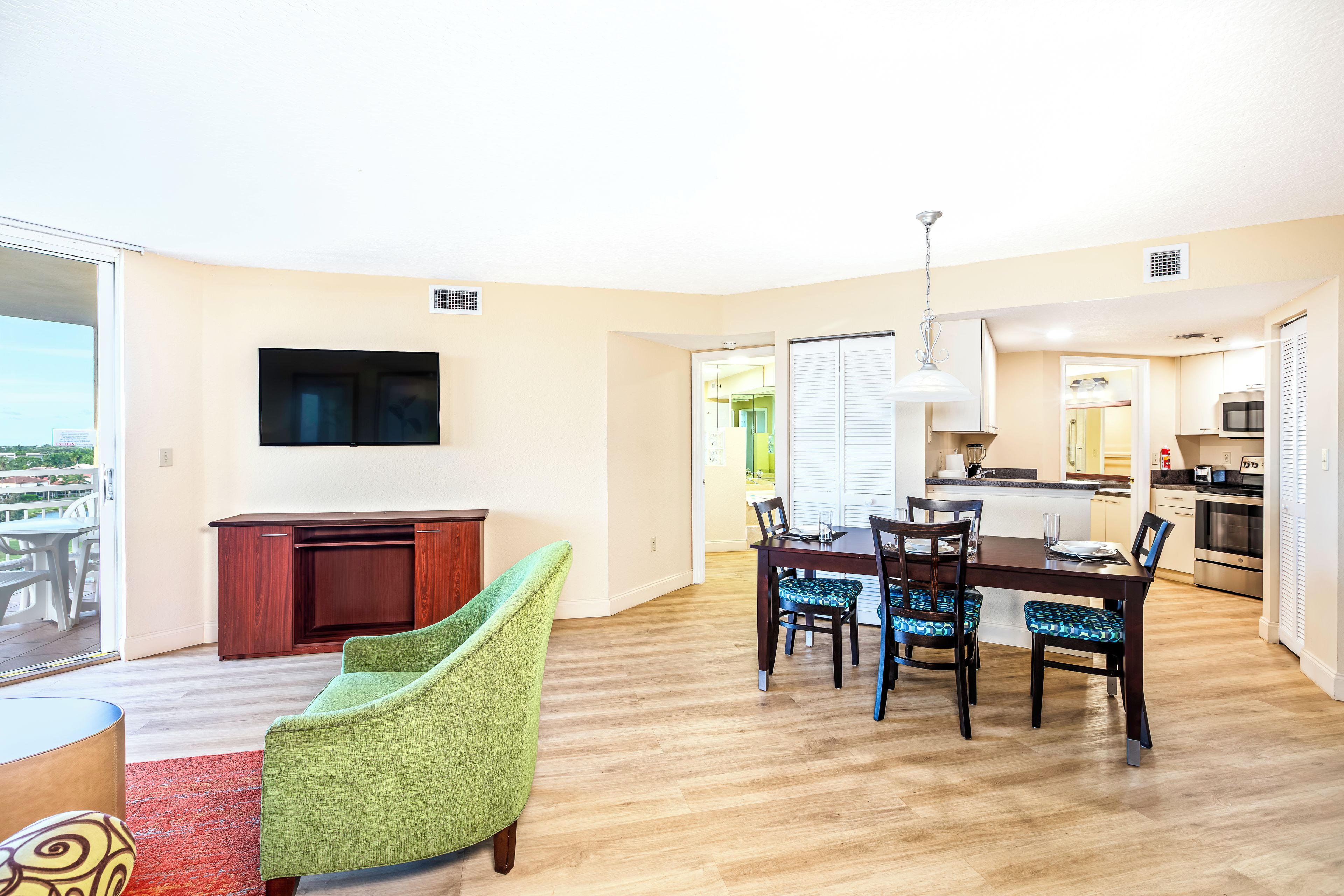 Un apartament modern amb zona de dinar, cuina i un balcó amb vistes.