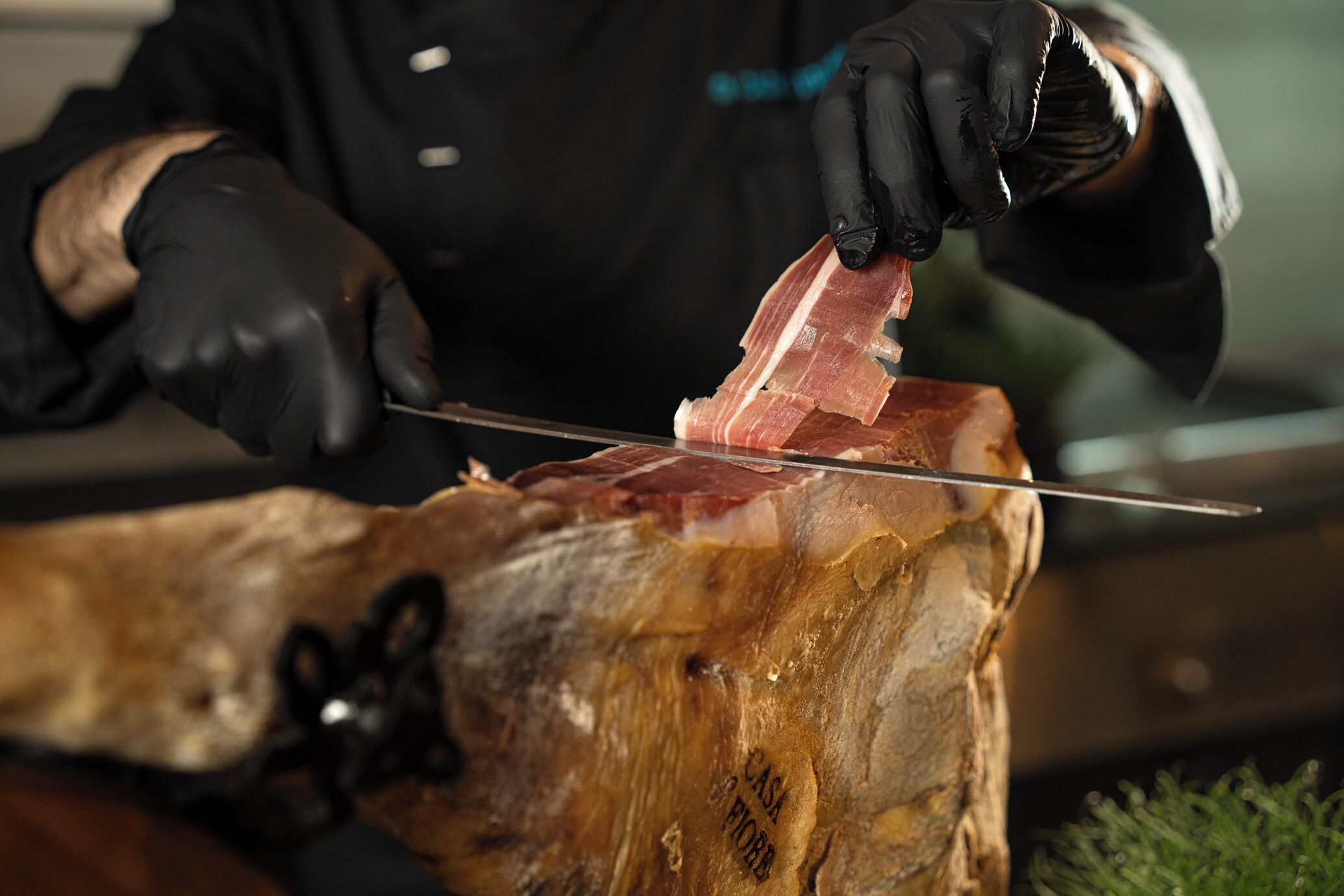 Alguém corta um pedaço grande de carne em uma tábua de madeira.
