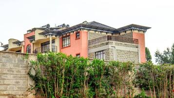 A multi-story building with a flat roof, large windows, and a balcony.