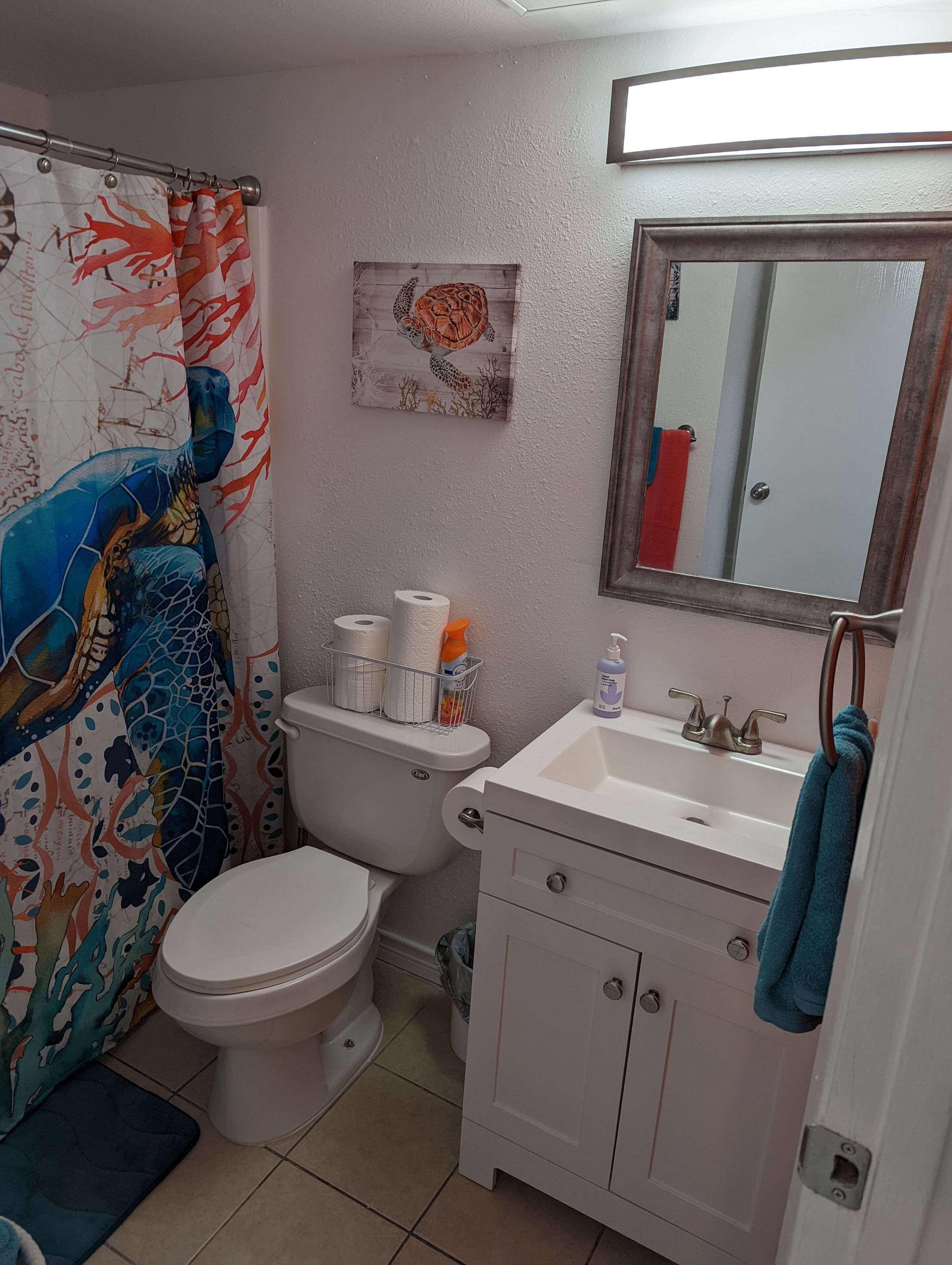 A bathroom with a toilet, sink, and shower curtain.