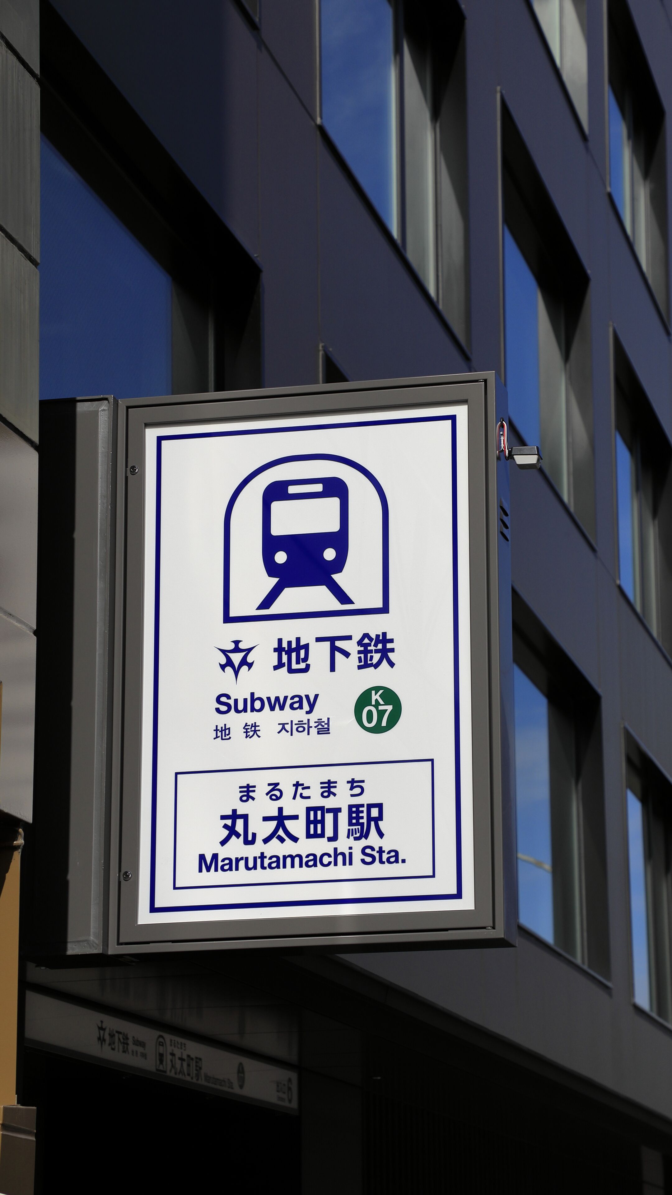 A subway station sign with Japanese text and a subway symbol.