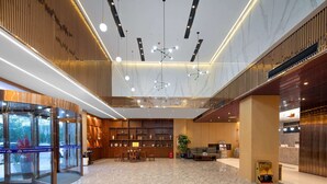 A spacious lobby with a marble floor, a reception desk, and a seating area. - Microtel by Wyndham Miluo Downtown Hotel (Yueyang)