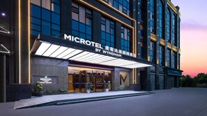 A hotel entrance with a prominent sign reading "MICROTEL BY WYNDHAM". - Microtel by Wyndham Miluo Downtown Hotel (Yueyang)