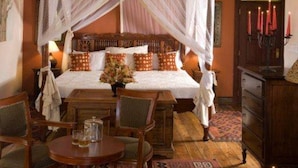 Une chambre à coucher avec un lit à baldaquin, une table en bois et une chaise.