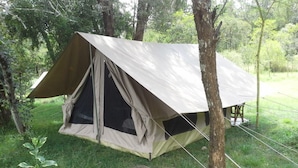 Tenda para uma pessoa montada em área arborizada com cobertura vegetal natural.