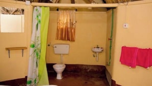 Casa de banho pequena com sanita, lavatório e cortina de chuveiro.