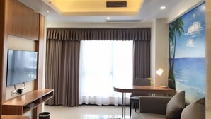 Un salon moderne doté d’un téléviseur à écran plat, d’un meuble de rangement en bois, d’une table basse en verre, d’un canapé, d’une table à manger avec des chaises et d’une grande fenêtre agrémentée de rideaux.