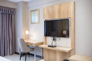 A hotel room with a desk, chair, TV, and a lamp. - Marco Polo Hotel (Jiangmen Wanda Plaza) (Jiangmen)