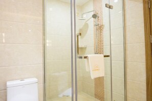 A glass-enclosed shower area with a white toilet visible to the left. - Marco Polo Hotel (Jiangmen Wanda Plaza) (Jiangmen)