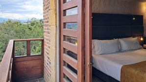 Een slaapkamer met een bed, een houten deur en een balkon.