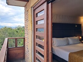 Un dormitorio con cama, una puerta de madera y un balcón.