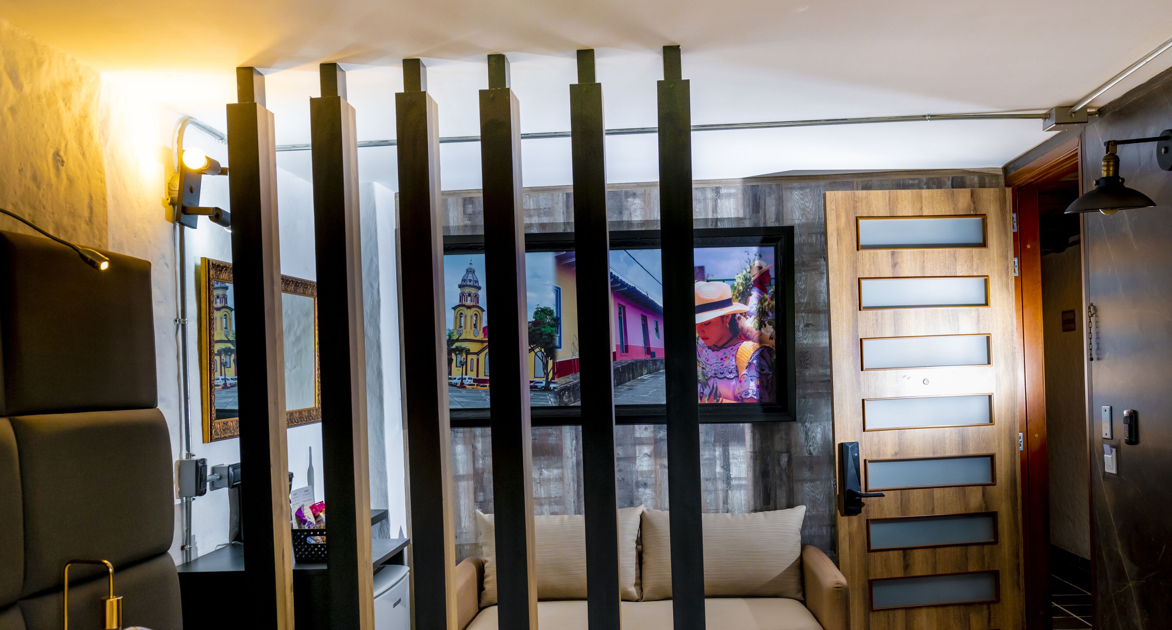 A modern room with a sofa, a television, and a wooden partition.